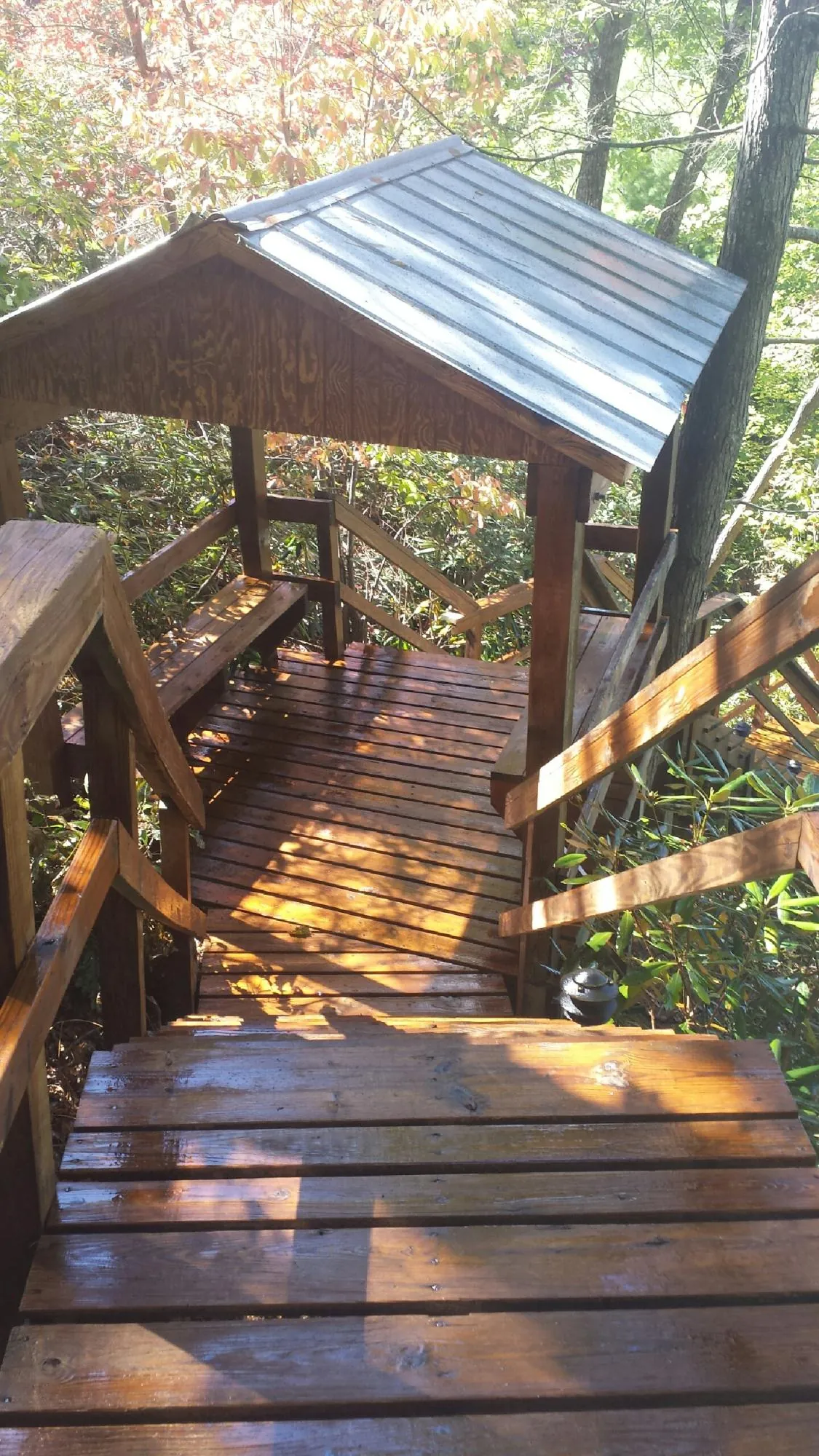 Freshly stained wood walkway and covered shelter with a metal roof in Wapanucka