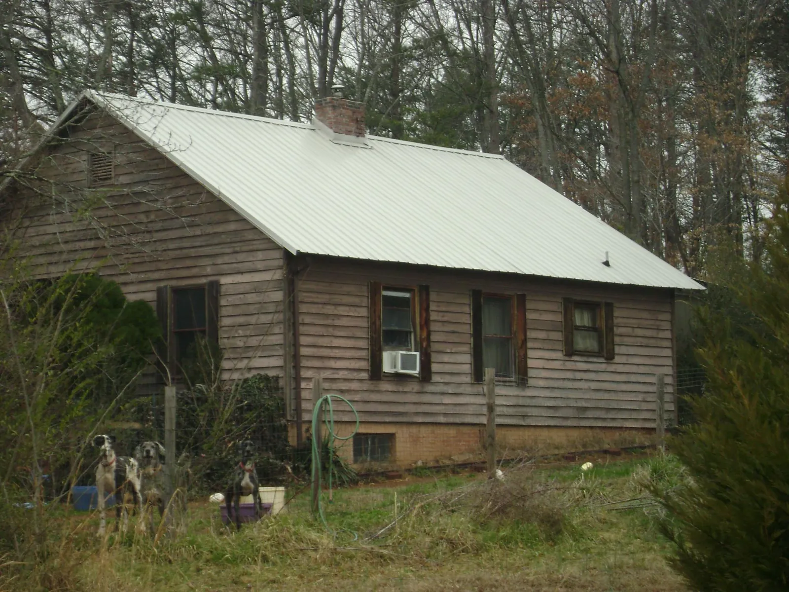 White metal roof on an old wood sided farmhouse, from a Metal Roof Installation job in Wapanucka